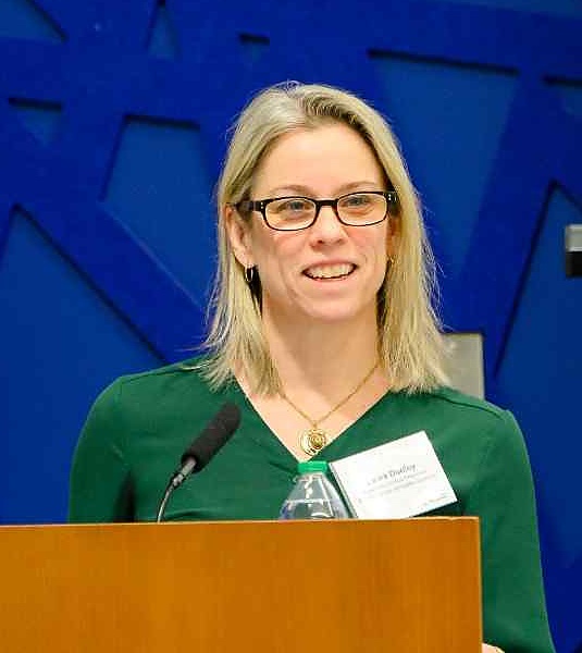 Dr. Laura Dudley speaking at a Northeastern podium